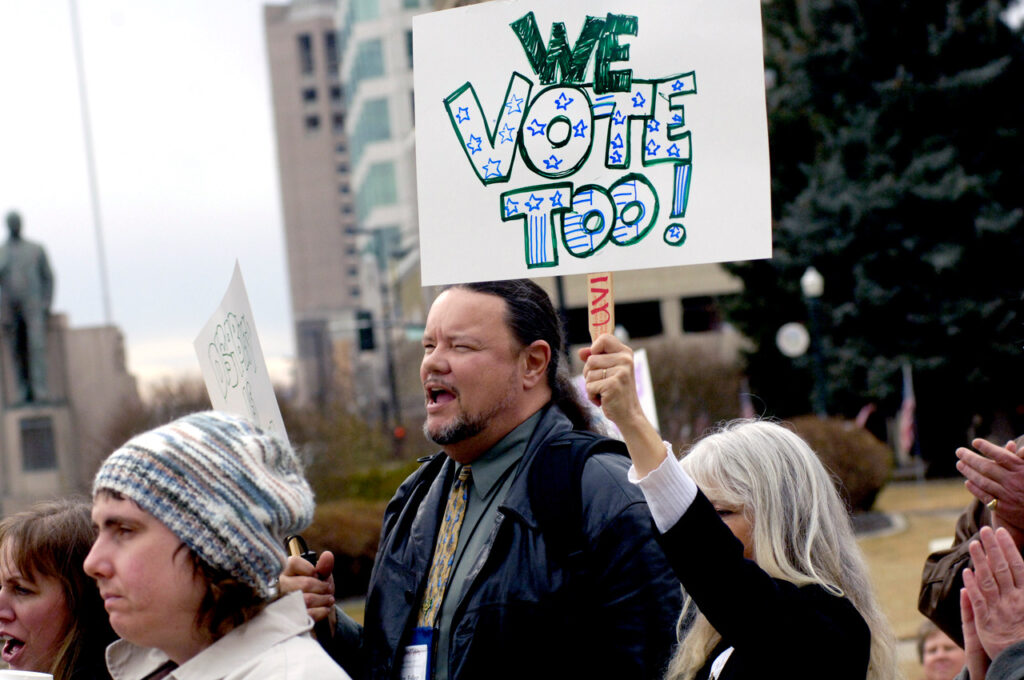 People holding signs to advocate for disability voting rights